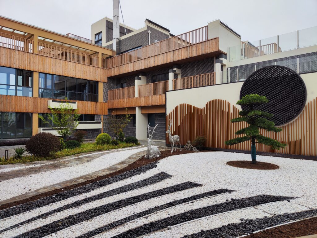 A tranquil modern courtyard featuring zen garden elements and wooden architectural accents.
